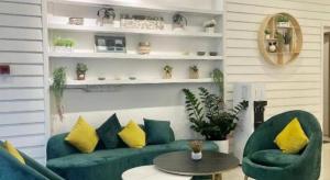 a living room with a green couch and two chairs at ATAP Hotel in Kota Kinabalu
