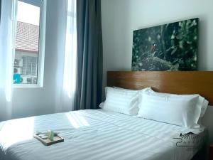 a bed in a hotel room with a tray on it at ATAP Hotel in Kota Kinabalu