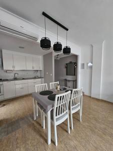 a dining room with a table and white chairs at Apartamento en Salobreña in Salobreña