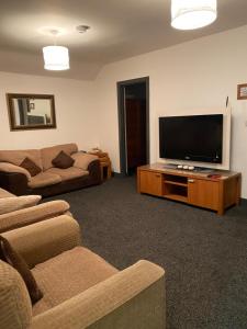 a living room with a flat screen tv and a couch at Stellas place in Birmingham