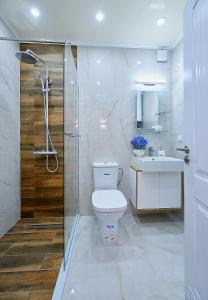 a bathroom with a toilet and a shower and a sink at Luxury Apartment Saint George Beauty and Style in Sveti Vlas