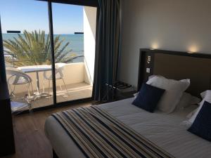 a bedroom with a bed with a view of the ocean at Hôtel Restaurant Splendid Camargue in Le Grau-du-Roi