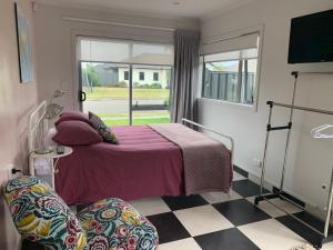 a bedroom with a bed and a checkered floor at 1 bedroom studio with 2 E-bikes for use in Napier