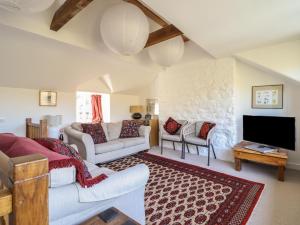 ein Wohnzimmer mit Sofa und Fernseher in der Unterkunft Clywedog Cottage in Dolgellau