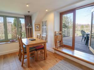 ein Esszimmer mit einem Tisch und Stühlen sowie einem Balkon in der Unterkunft Clywedog Cottage in Dolgellau