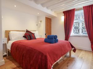 ein Schlafzimmer mit einem großen Bett mit einer roten Decke in der Unterkunft Clywedog Cottage in Dolgellau