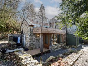 ein Steinhaus mit Balkon darüber in der Unterkunft Clywedog Cottage in Dolgellau