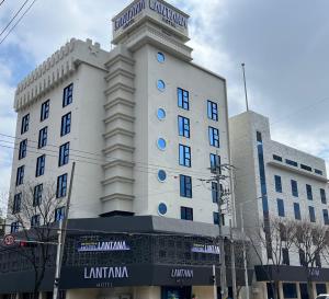 光州Cheomdan Lantana Hotel的白色的建筑,上面有标志