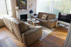 a living room with two couches and a television at Kustverhuur, Park Schoneveld Duinroos 131 in Breskens