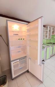 a white refrigerator with its door open in a kitchen at Home in Ban Nong Hin