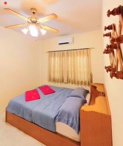 a bedroom with a bed and a ceiling fan at Home in Ban Nong Hin +27 photos
