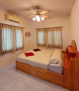 a bedroom with a bed and a ceiling fan at Home in Ban Nong Hin
