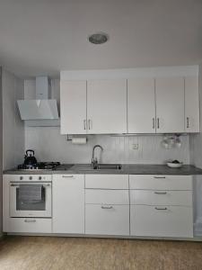 a white kitchen with white cabinets and a sink at Apartamento en Salobreña in Salobreña
