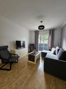 a living room with a couch and a tv at Apartamento en Salobreña in Salobreña +10 photos