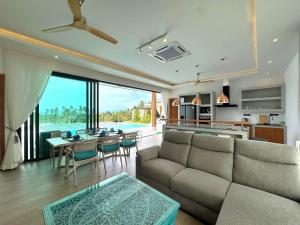 a living room with a couch and a table at Sunterra villa Seaview in Amphoe Koh Samui