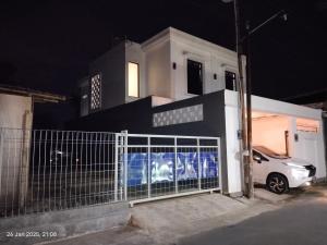 a white car parked in front of a house at night at Majid's Homestay Solo in Kartosuro