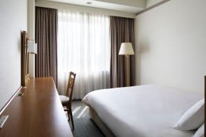 Postel nebo postele na pokoji v ubytování The Mark Grand Hotel