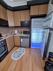 a kitchen with an open refrigerator and a wooden floor at 2 EGE Üniversite ve Hastanesi YAKINI , Aileye ve Firma Çalışanlarına uygun in Burunabat