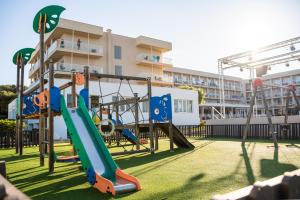 a playground in front of a building with a slide at Minura Sur Menorca in Punta Prima