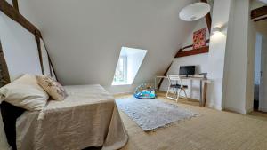 a bedroom with a bed and a desk with a chair at Détente au cœur du Perche in Senonches