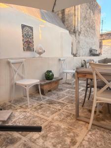 a room with chairs and a table and a table and a table at PalazzOliva - Luxury Boho chic Guest house in the historic heart of Martina Franca in Martina Franca