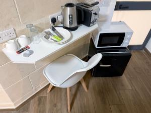 a white chair sitting next to a counter with a coffee maker at Mini Studios in Central Victoria in Victoria +40 photos