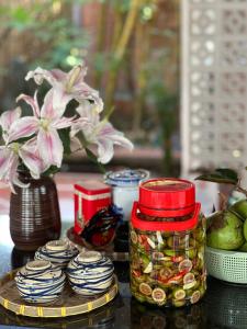 a table with a jar of pickles and a vase with flowers at Ann - Hồ Tràm Garden Villa in Xuyên Mộc +61 photos
