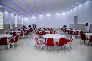 a large room with tables and red chairs at SkyLine View Hotel in Mama
