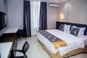 a hotel room with a large bed and a desk at SkyLine View Hotel in Mama