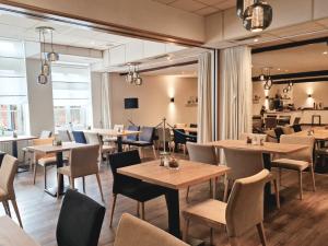 a restaurant with tables and chairs in a room at Hotel Altes Land in Jork
