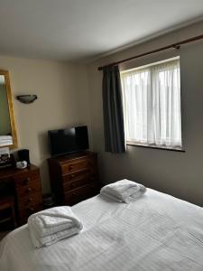 a bedroom with a bed with two towels on it at The Fountain Inn Tenbury Wells in Tenbury