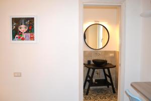 een badkamer met een spiegel en een tafel bij Domo e Sorres in Olbia