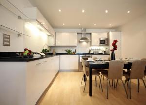 a kitchen and dining room with a table and chairs at Reading Modern Two Bedroom Apartment in Reading
