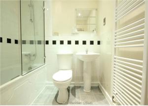 a white bathroom with a toilet and a sink at Reading Modern Two Bedroom Apartment in Reading