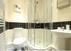 a bathroom with a shower and a toilet and a sink at Reading Modern Two Bedroom Apartment in Reading