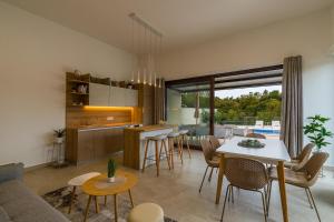 een keuken en woonkamer met een tafel en stoelen bij Villa Lo La by Istrialux in Svetvinčenat