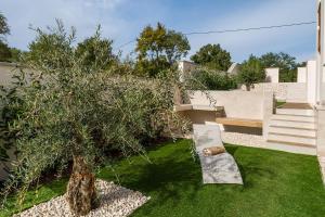 een boom in de tuin van een huis met een bank bij Villa Lo La by Istrialux in Svetvinčenat