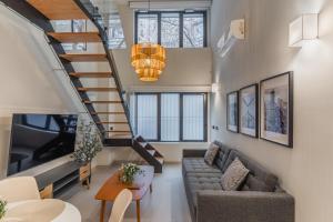 un soggiorno con una scala e un divano di LAUREL-MintyStay Apartments a Madrid