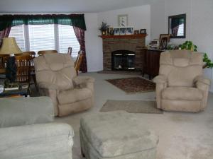 a living room with two chairs and a fireplace at Rainbow House in Angel Fire