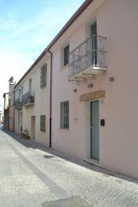 een wit gebouw met een deur en een balkon bij Domo e Sorres in Olbia