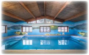 a swimming pool in a room with a painting on the wall at Blelham Tarn Rustic cabin in tranquil woodland in Ambleside