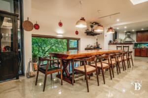 a kitchen with a large wooden table and chairs at Bách Việt Villa Retreat Sân Golf Tam Đảo in Tam Ðảo