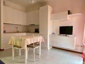 a kitchen with a table and chairs and a television at Cardinali House in Cattolica