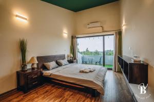 a bedroom with a large bed and a large window at Bách Việt Villa Retreat Sân Golf Tam Đảo in Tam Ðảo +27 photos