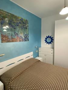 a bedroom with a bed and a painting on the wall at Cardinali House in Cattolica