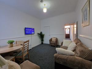 a living room with a couch and a table and a tv at Nice Living Serviced Accommodations 12 in Coventry +11 photos