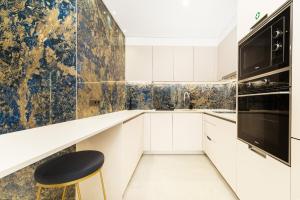 a kitchen with white cabinets and a black appliance at Safira Suites 101 in Funchal +39 photos