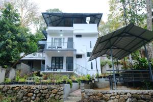 a house with two black umbrellas in front of it at Riverside Bliss Villa in Kallar-Bridge