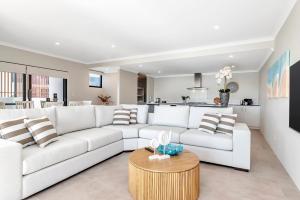 a living room with a white couch and a table at Oceanfront Retreat With Stunning Marina Views in Mandurah
