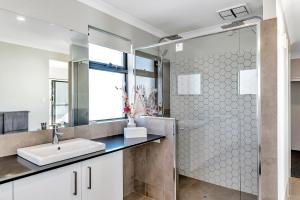 a bathroom with a sink and a shower at Oceanfront Retreat With Stunning Marina Views in Mandurah +53 photos